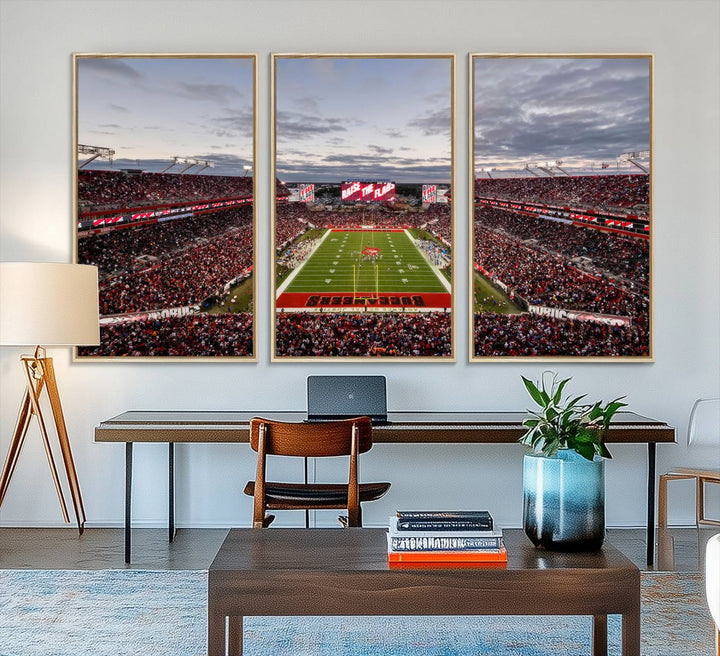 The wall art captures a stunning scene of Raymond James Stadium bathed in the warm hues of sunset. The sky, filled with clouds, provides a dramatic contrast to the vibrant lighting on the field, encapsulating the dynamic energy of a football game.