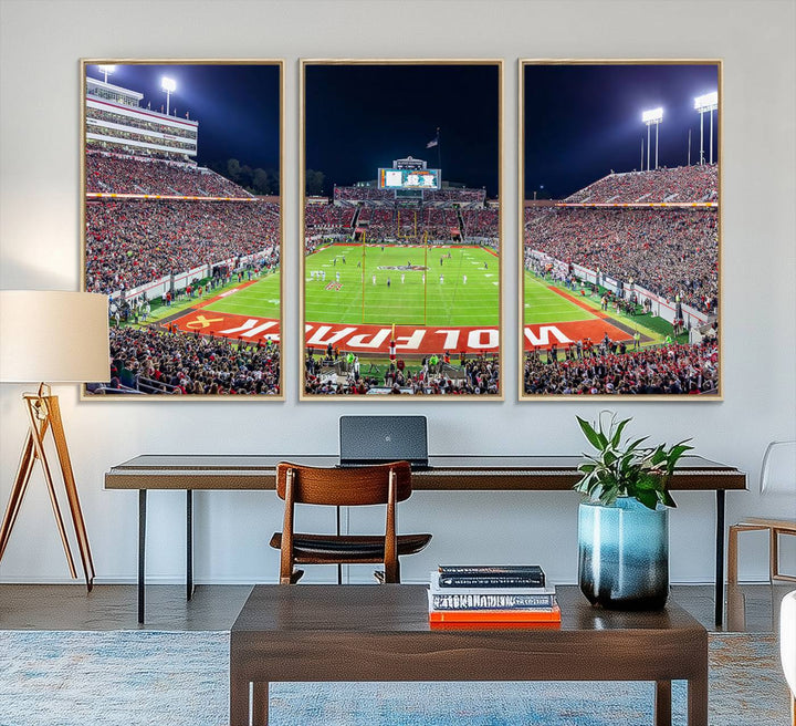 A NC State Wolfpack Football Team print of Carter-Finley Stadium at night features WOLFPACK illuminated brightly in the end zone grass.