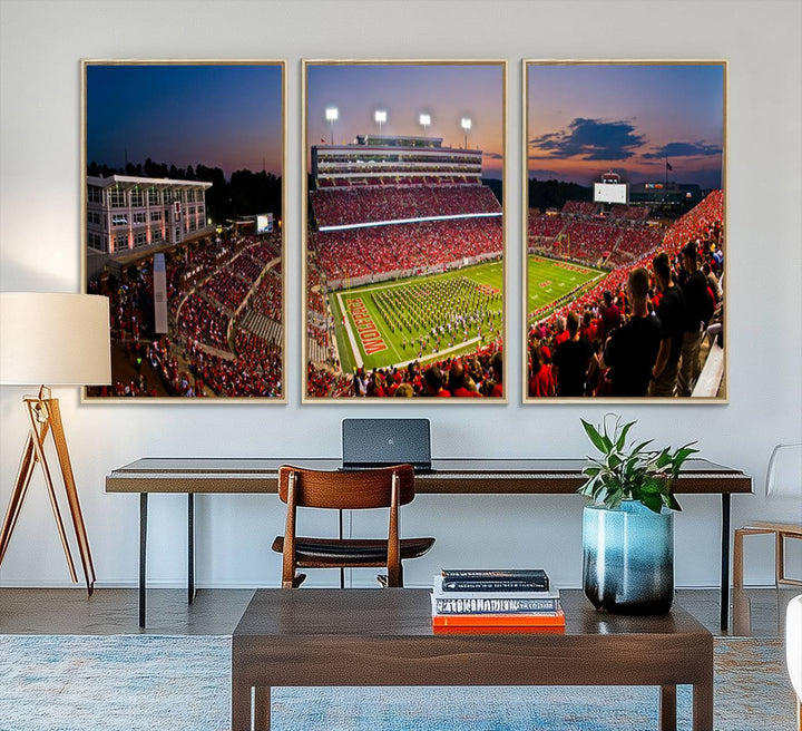 A print of a bustling Carter-Finley Stadium at dusk, featuring fans and a band, captures the essence of NC State Wolfpack football.