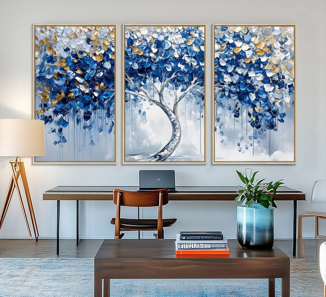 The Blue and Gold Abstract Tree Wall Art showcases a swirl trunk and features blue, silver, and gold leaves on a framed canvas print.