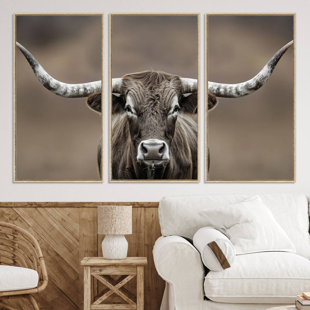 A close-up of a longhorn bull facing forward is featured in the Framed Texas Test-1, set against a blurred brown background.