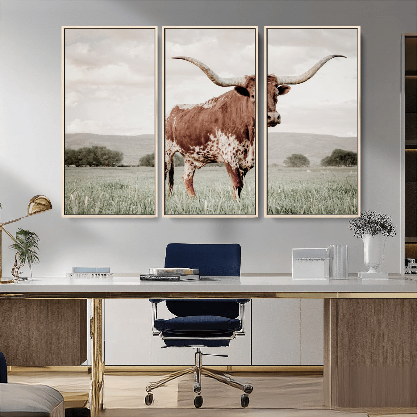 Canvas of a Texas longhorn standing in a grassy field with mountains in the background, ideal for rustic or country-style western wall decor.
