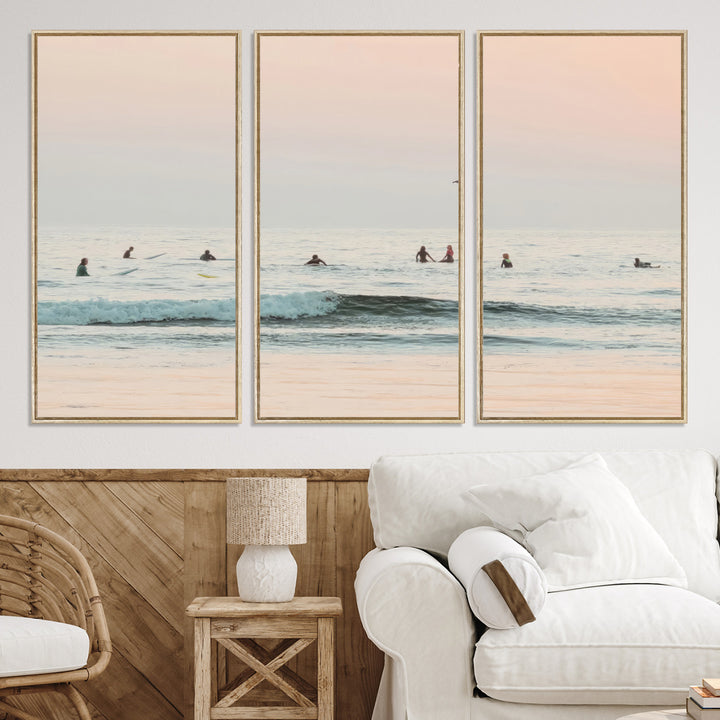 Dreamy photo of surfers waiting on soft pastel waves under a pink sunset sky, ideal for soft coastal minimalist or serene ocean-themed home decor.