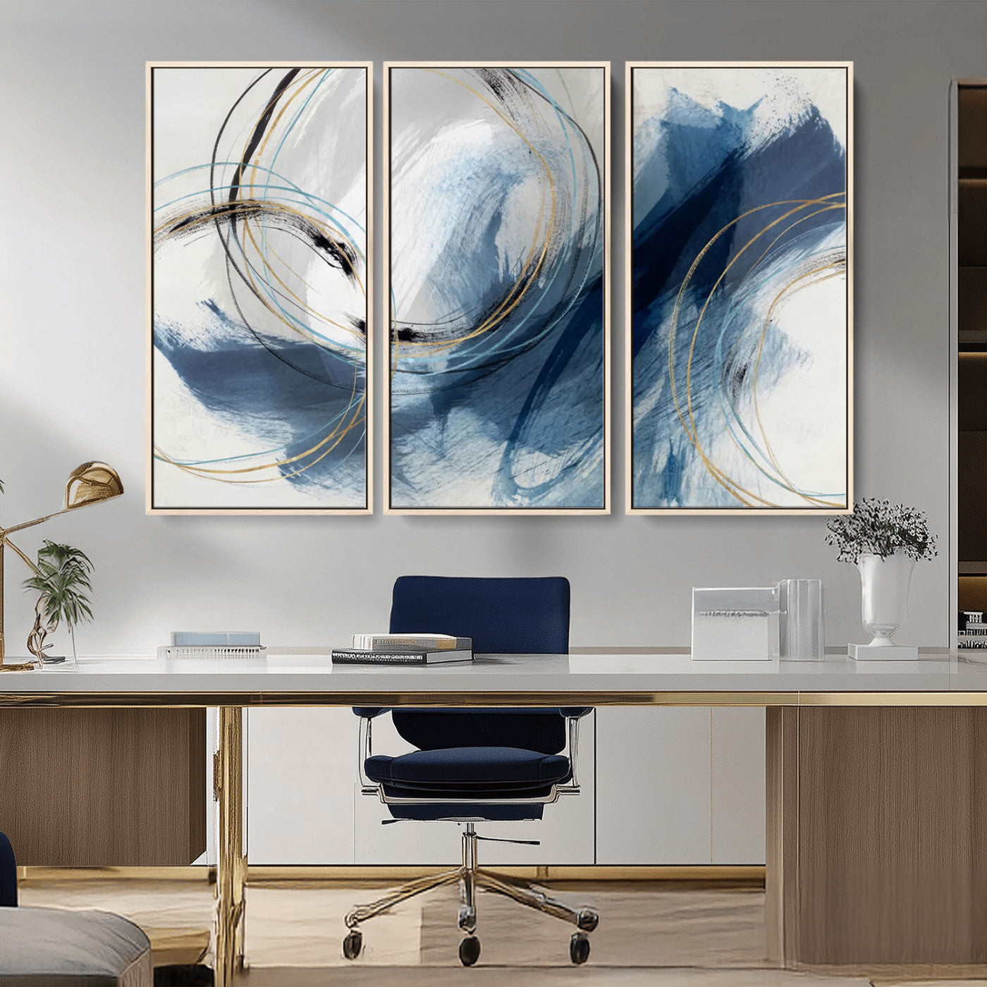 Abstract wall art featuring dynamic brush strokes in shades of blue and gray, overlaid with delicate circular line patterns in gold, black, and light blue on a white background.