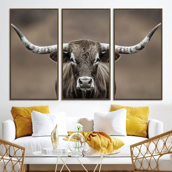 A close-up of a longhorn bull facing forward is featured in the Framed Texas Test-1, set against a blurred brown background.