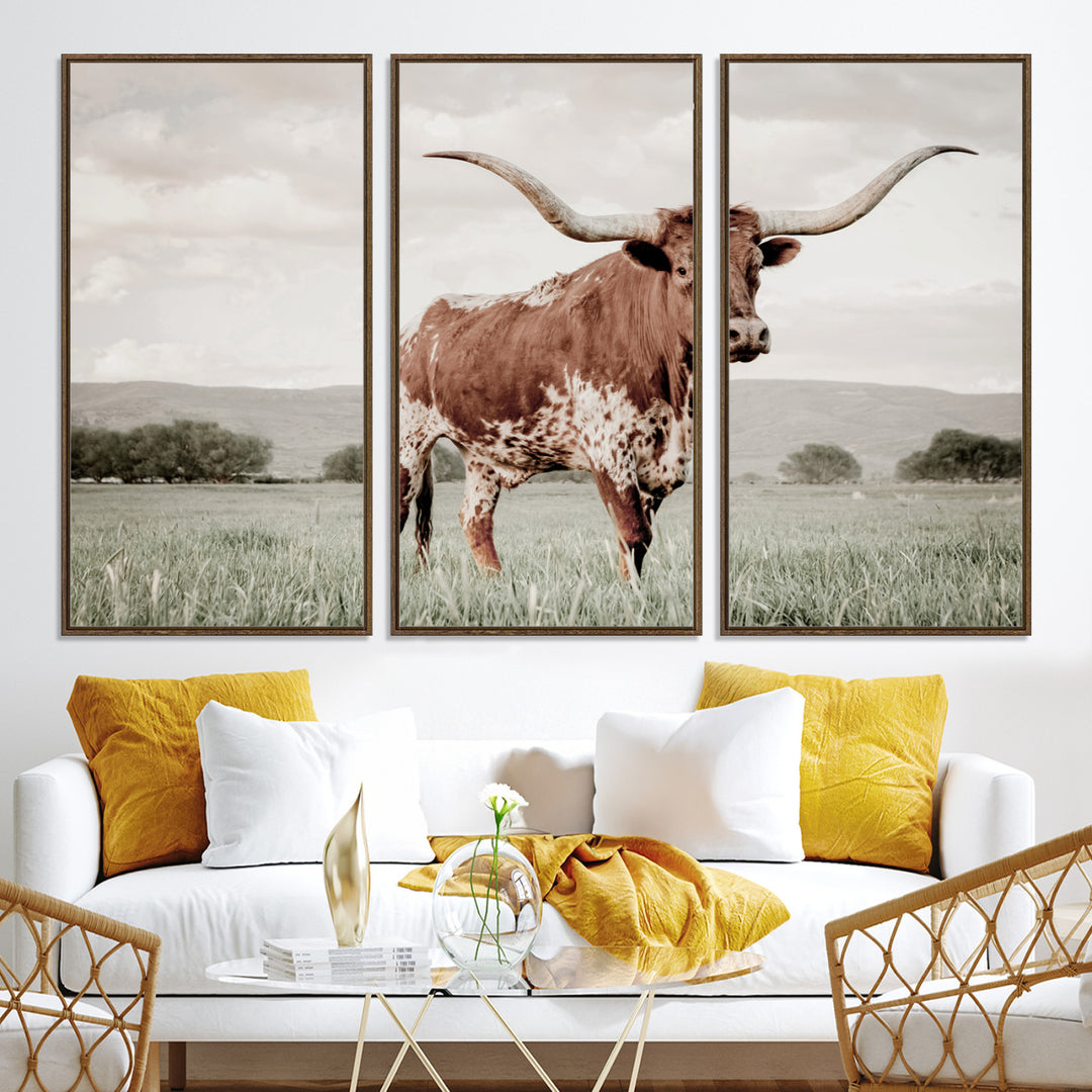 Canvas of a Texas longhorn standing in a grassy field with mountains in the background, ideal for rustic or country-style western wall decor.