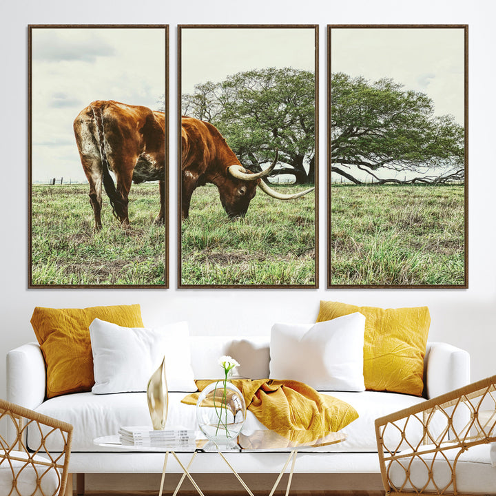 A Texas Longhorn grazing in a green pasture with a large tree in the background, evoking a rustic Western and farmhouse aesthetic.