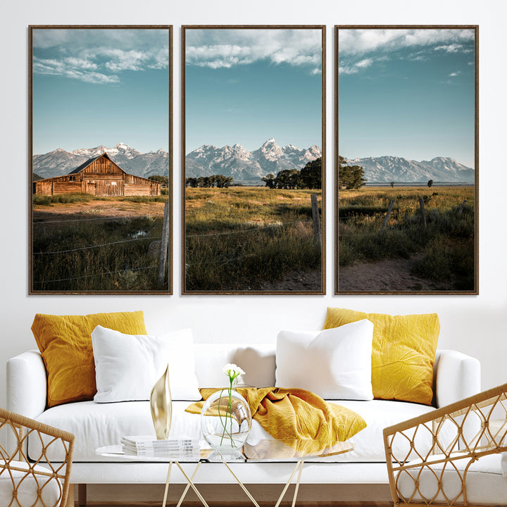 A rustic farmhouse with a wooden barn set against majestic mountain peaks under a soft blue sky, evoking peaceful countryside charm.