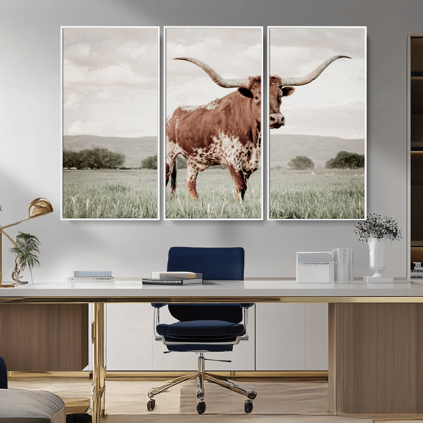 Canvas of a Texas longhorn standing in a grassy field with mountains in the background, ideal for rustic or country-style western wall decor.