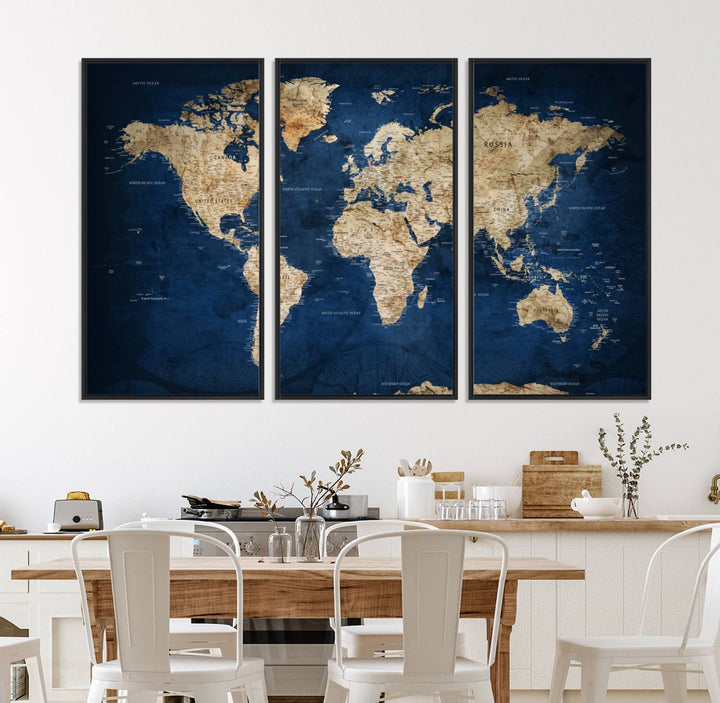 A large framed world map canvas print features beige landmasses set against a grunge-stained deep blue ocean background, creating an intriguing piece of wall art.