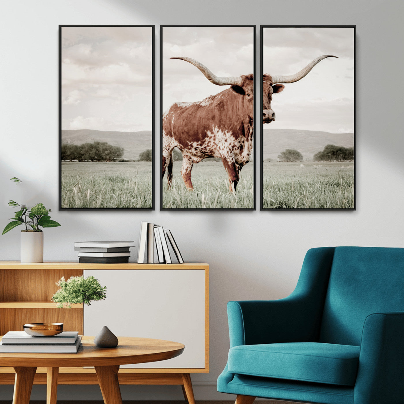 Canvas of a Texas longhorn standing in a grassy field with mountains in the background, ideal for rustic or country-style western wall decor.