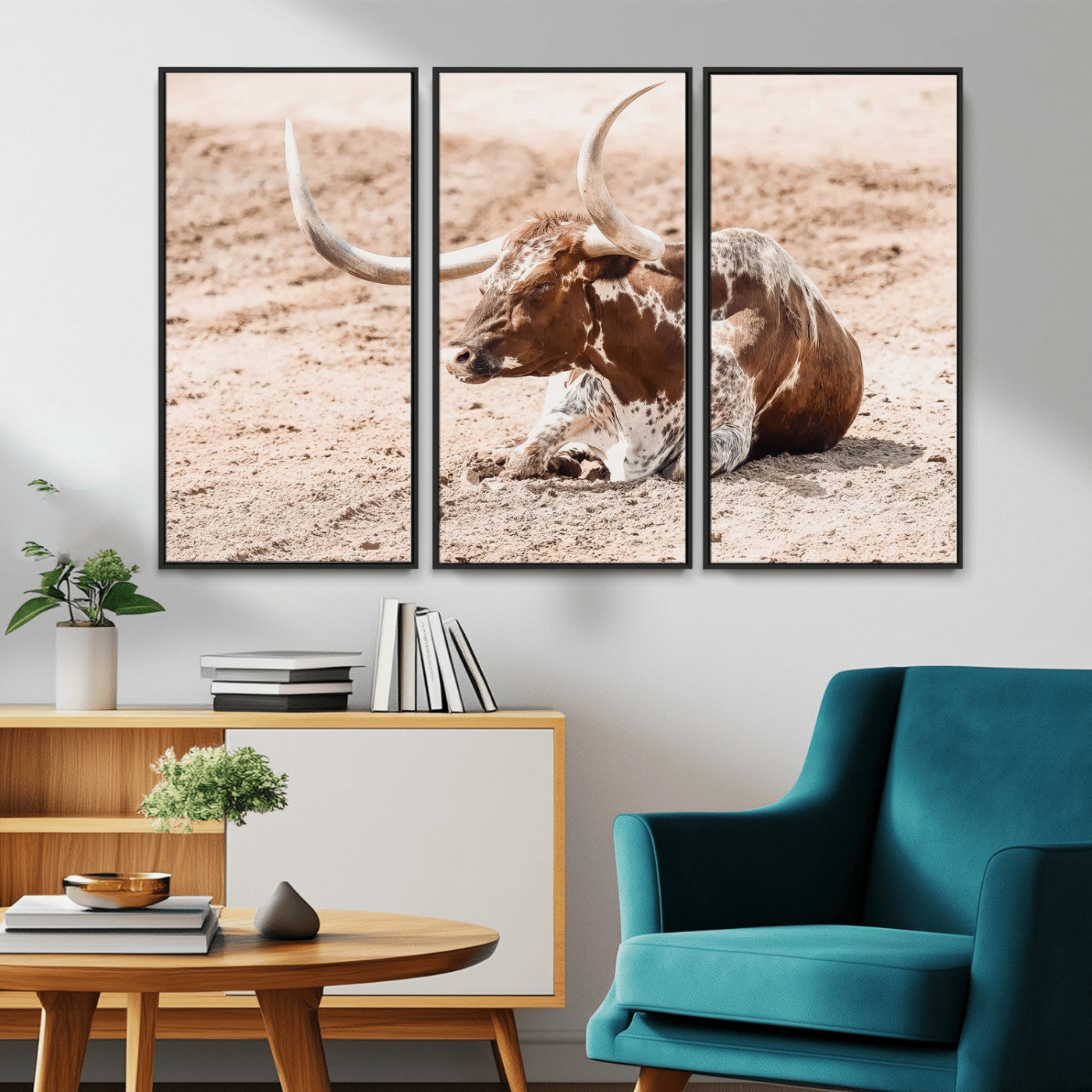Texas Longhorn bull resting on dusty ground with warm tones, ideal for rustic western or farmhouse-themed wall decor.