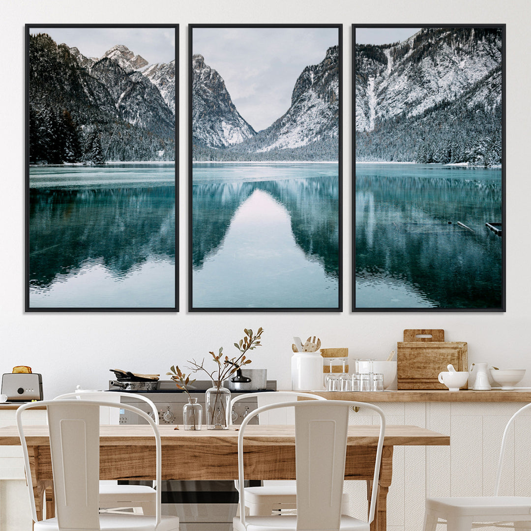 Crystal-clear alpine lake reflecting snow-covered mountains, surrounded by evergreen trees, creating a serene and tranquil winter landscape.