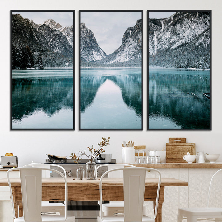 Crystal-clear alpine lake reflecting snow-covered mountains, surrounded by evergreen trees, creating a serene and tranquil winter landscape.