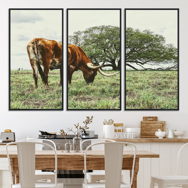 A Texas Longhorn grazing in a green pasture with a large tree in the background, evoking a rustic Western and farmhouse aesthetic.