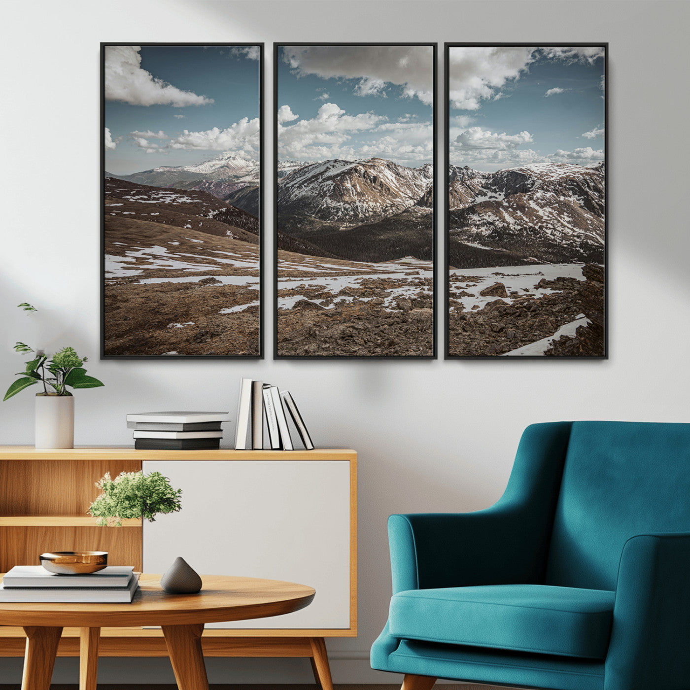 A breathtaking mountain landscape with rugged peaks, patches of snow, and dramatic clouds casting shadows over the vast alpine wilderness.