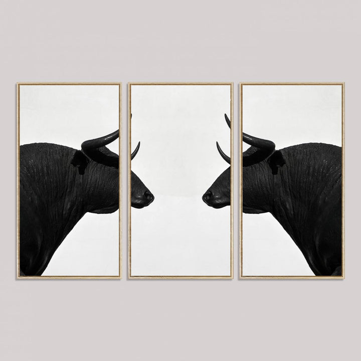 A framed canvas print featuring two black bull silhouettes, perfect for modern rustic decor.