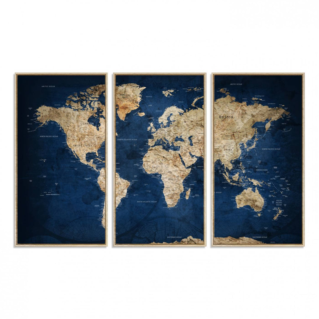 A large framed world map canvas print features beige landmasses set against a grunge-stained deep blue ocean background, creating an intriguing piece of wall art.