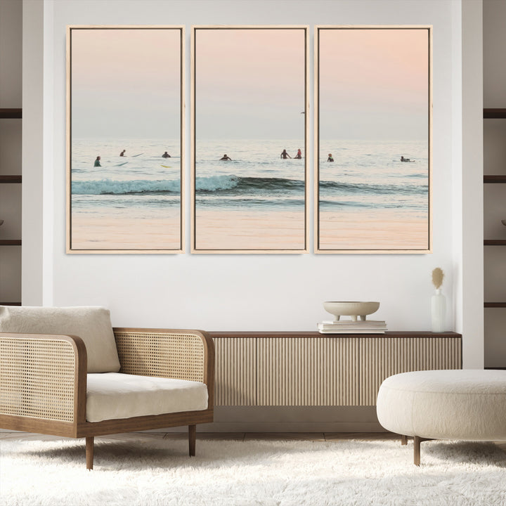 Dreamy photo of surfers waiting on soft pastel waves under a pink sunset sky, ideal for soft coastal minimalist or serene ocean-themed home decor.