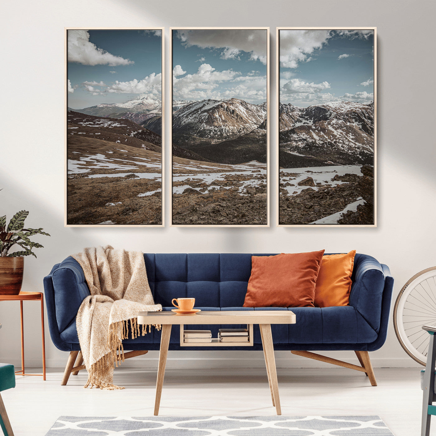 A breathtaking mountain landscape with rugged peaks, patches of snow, and dramatic clouds casting shadows over the vast alpine wilderness.