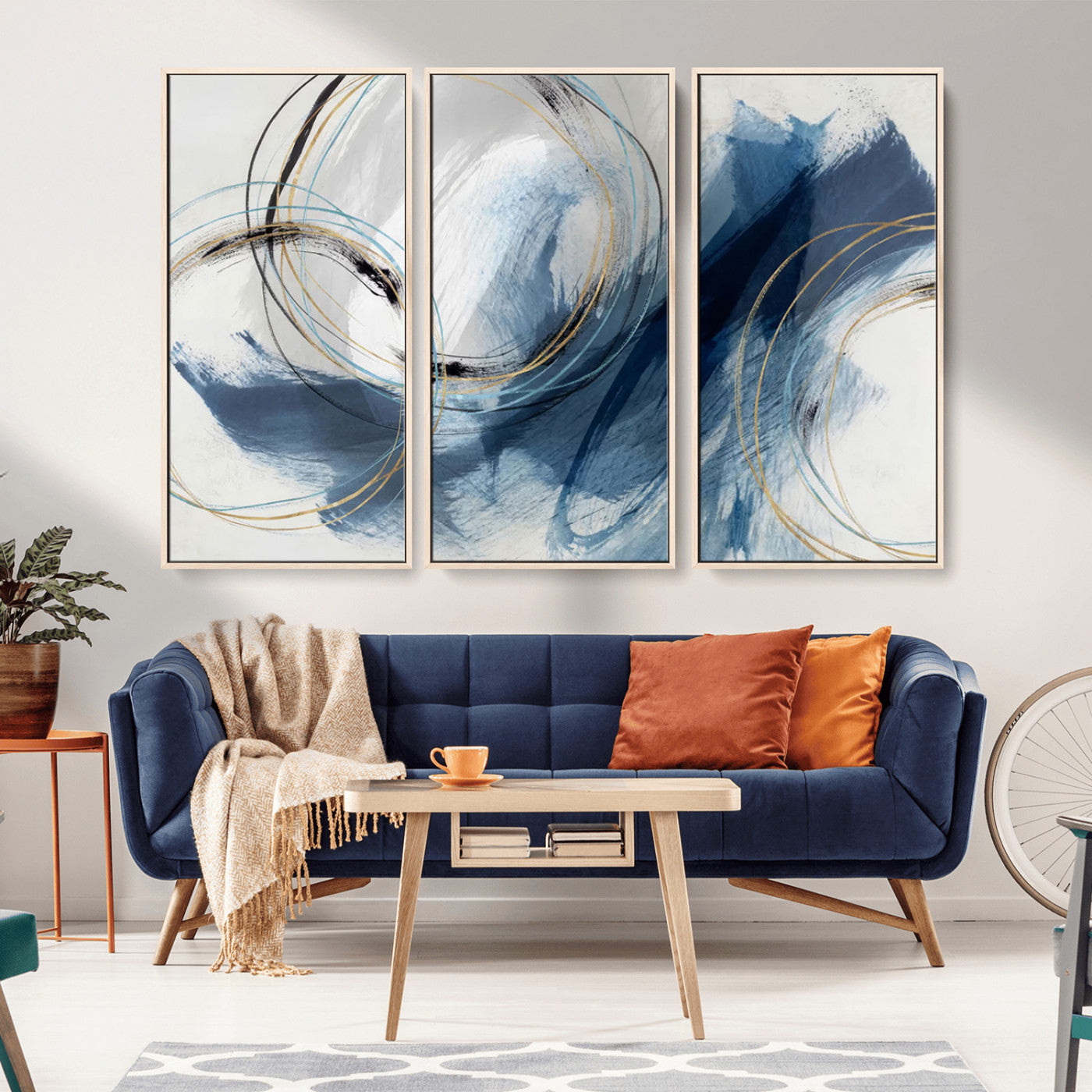 Abstract wall art featuring dynamic brush strokes in shades of blue and gray, overlaid with delicate circular line patterns in gold, black, and light blue on a white background.