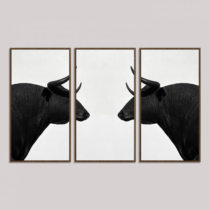 A framed canvas print featuring two black bull silhouettes, perfect for modern rustic decor.