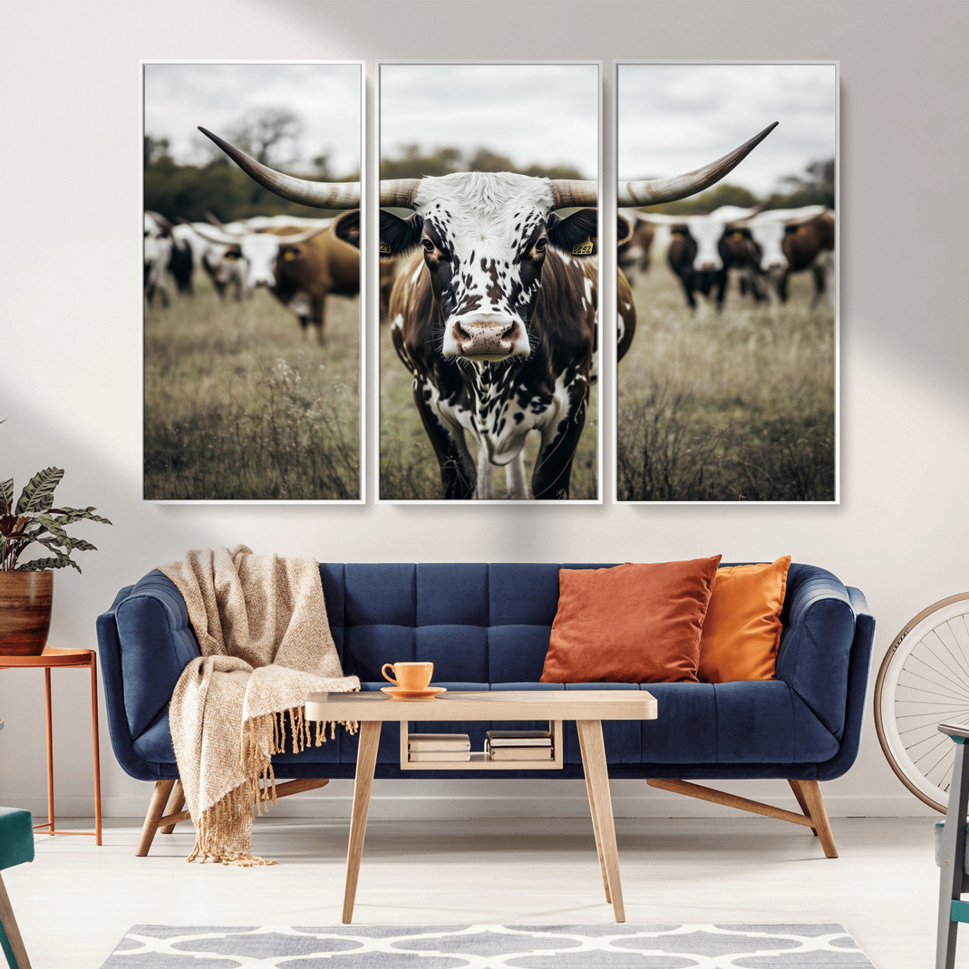 Canvas of a speckled Texas longhorn standing boldly in a field with a herd behind, perfect for rustic western or farmhouse wall decor.