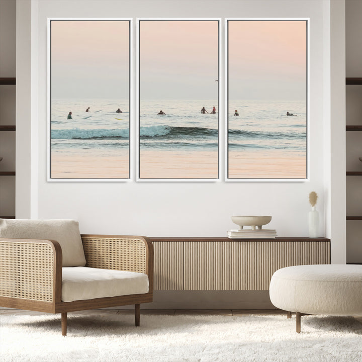 Dreamy photo of surfers waiting on soft pastel waves under a pink sunset sky, ideal for soft coastal minimalist or serene ocean-themed home decor.