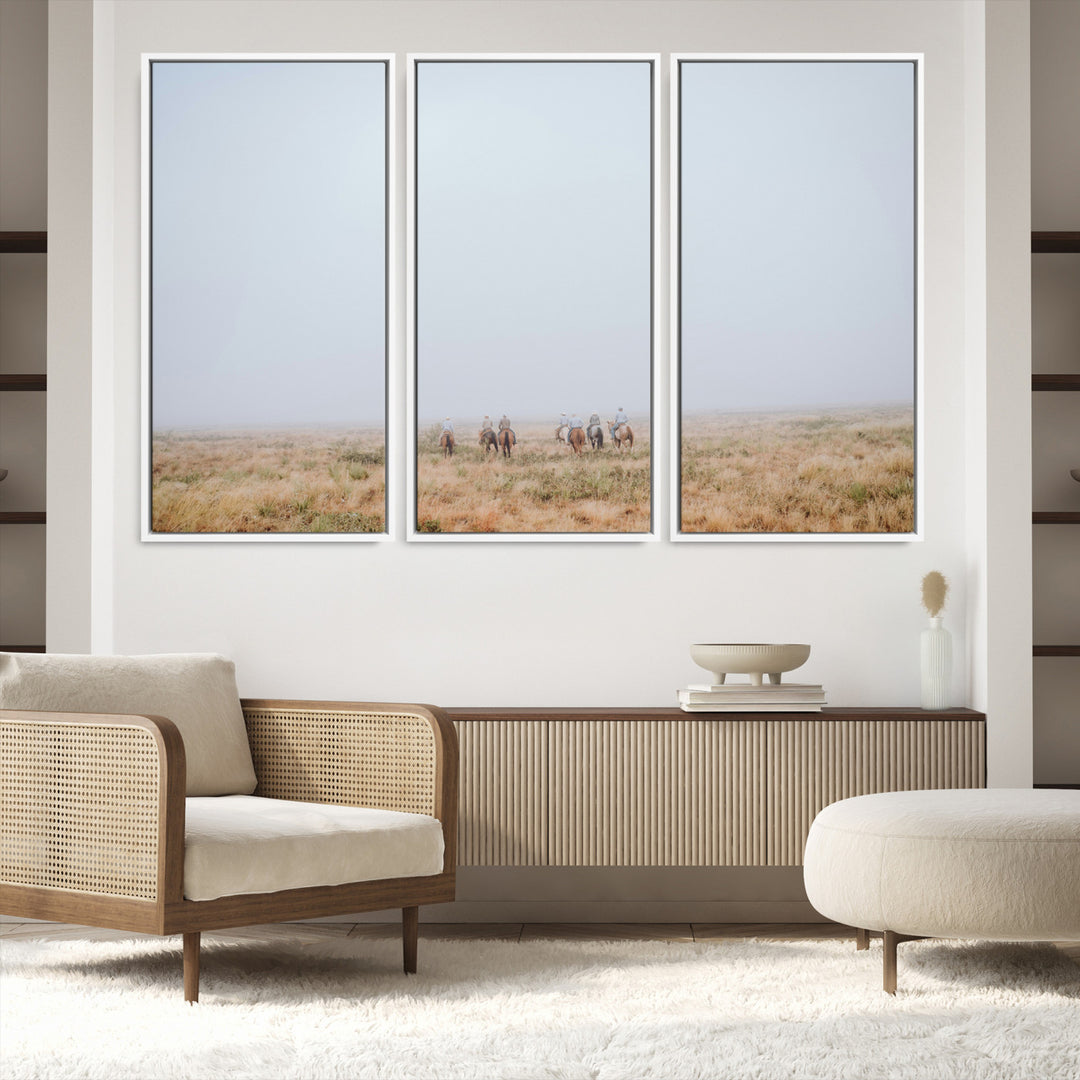 A group of horseback riders moving through a fog-shrouded field, evoking a calm Western scene with golden grasses and soft horizons.