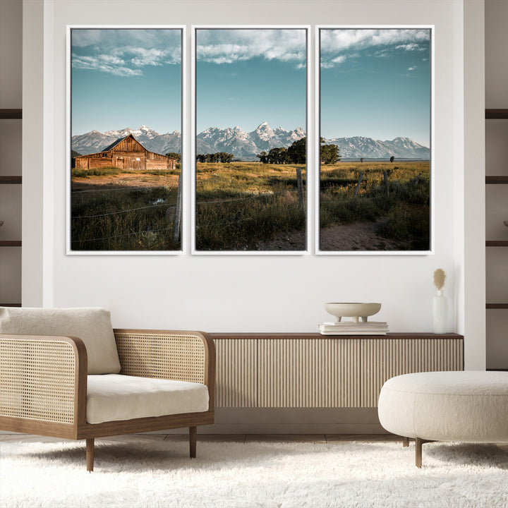 A rustic farmhouse with a wooden barn set against majestic mountain peaks under a soft blue sky, evoking peaceful countryside charm.