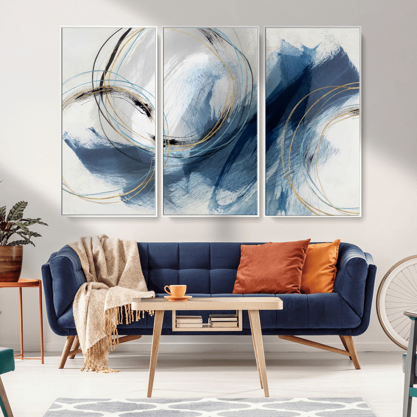 Abstract wall art featuring dynamic brush strokes in shades of blue and gray, overlaid with delicate circular line patterns in gold, black, and light blue on a white background.