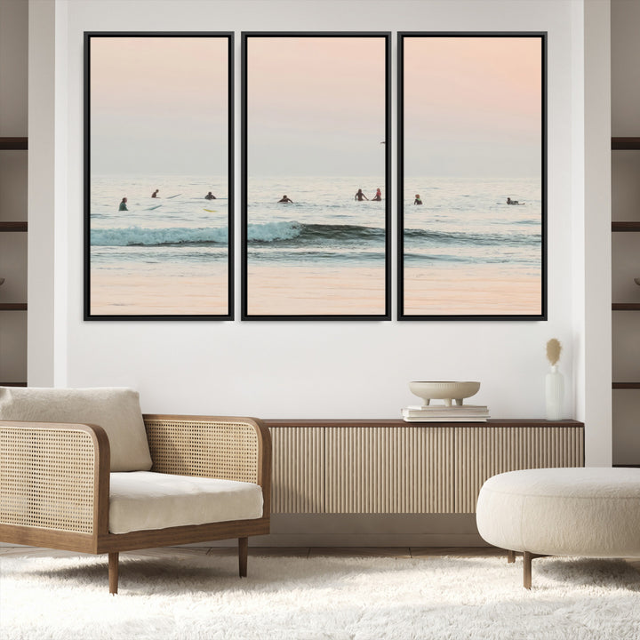 Dreamy photo of surfers waiting on soft pastel waves under a pink sunset sky, ideal for soft coastal minimalist or serene ocean-themed home decor.