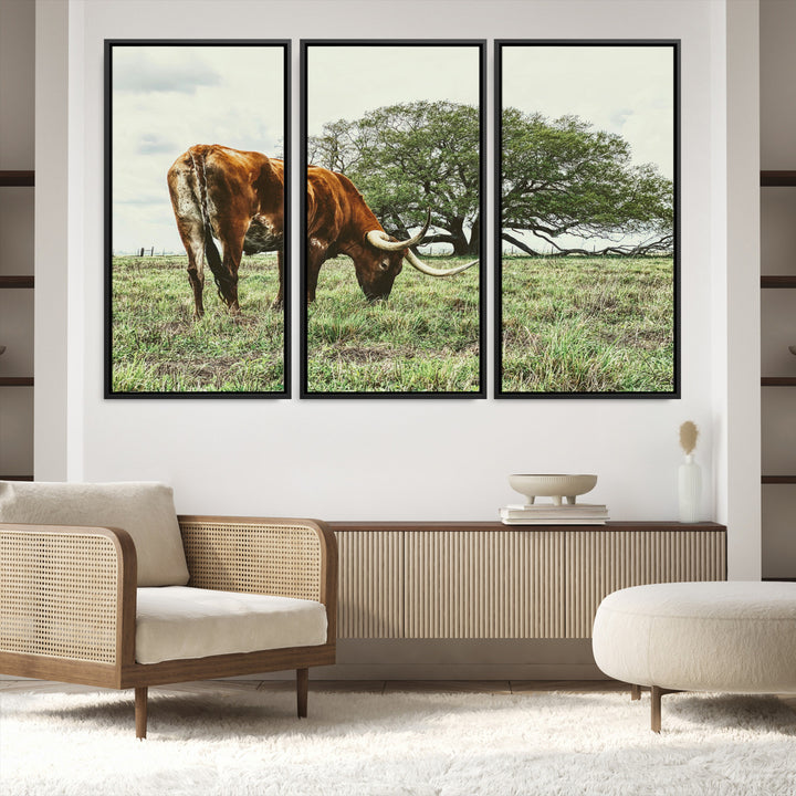 A Texas Longhorn grazing in a green pasture with a large tree in the background, evoking a rustic Western and farmhouse aesthetic.