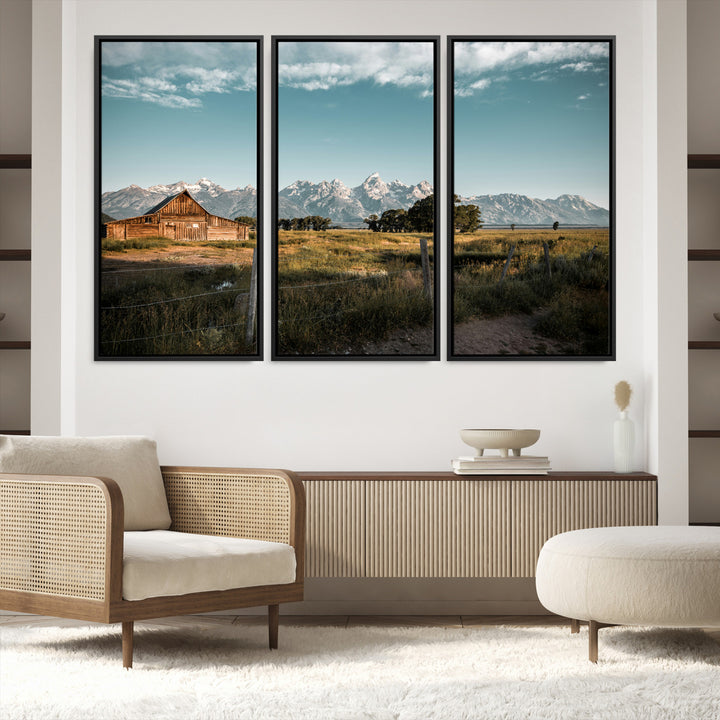 A rustic farmhouse with a wooden barn set against majestic mountain peaks under a soft blue sky, evoking peaceful countryside charm.