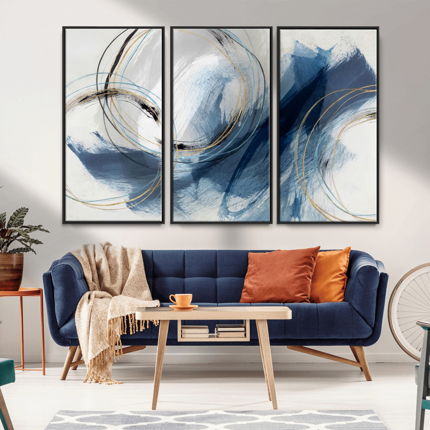 Abstract wall art featuring dynamic brush strokes in shades of blue and gray, overlaid with delicate circular line patterns in gold, black, and light blue on a white background.