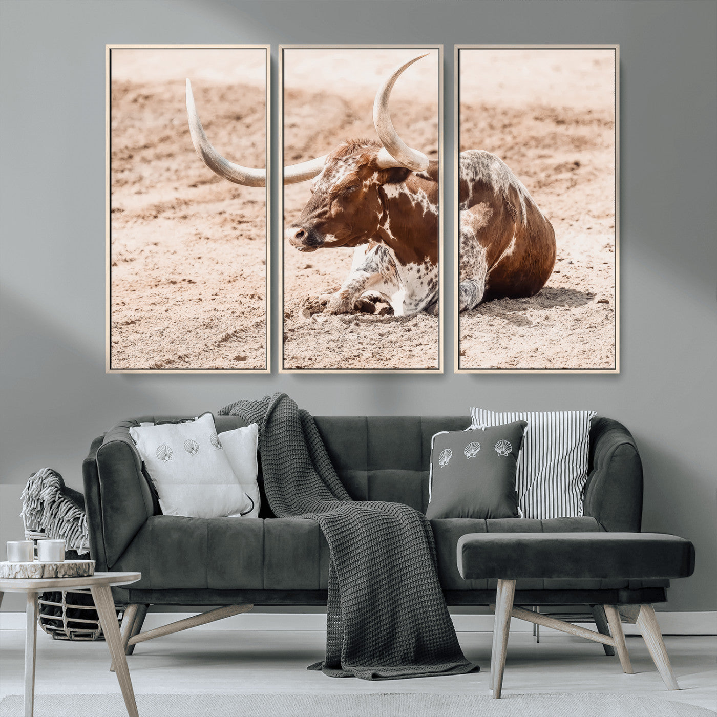 Texas Longhorn bull resting on dusty ground with warm tones, ideal for rustic western or farmhouse-themed wall decor.