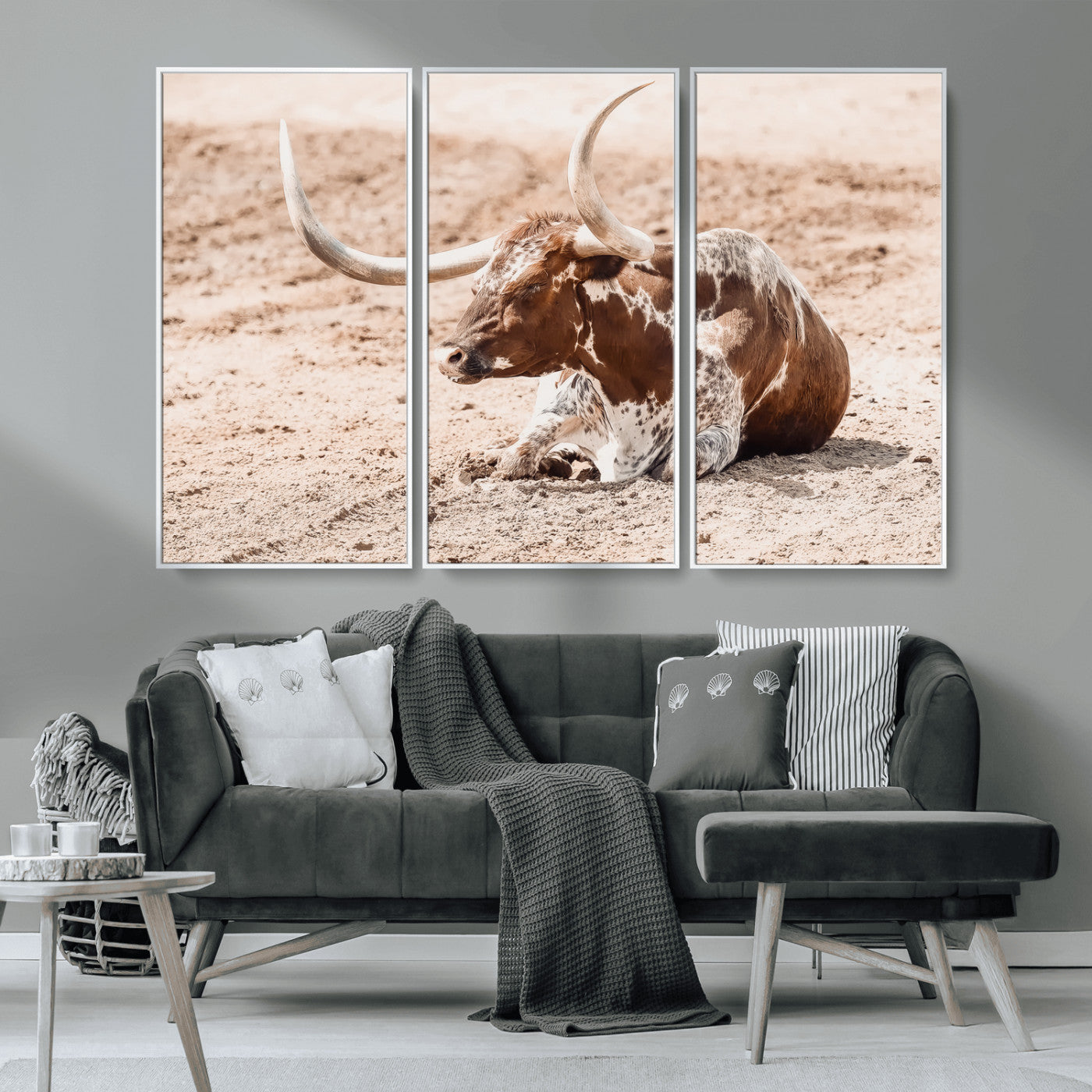Texas Longhorn bull resting on dusty ground with warm tones, ideal for rustic western or farmhouse-themed wall decor.