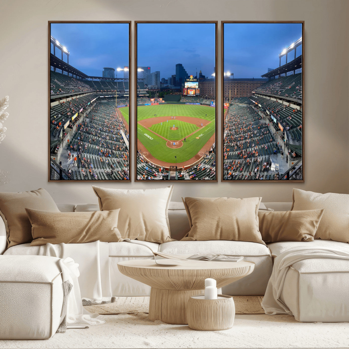 Wide panoramic view of a baseball stadium at dusk with players on the field, stadium lights illuminating the scene, and a sparse crowd of spectators in the stands.
