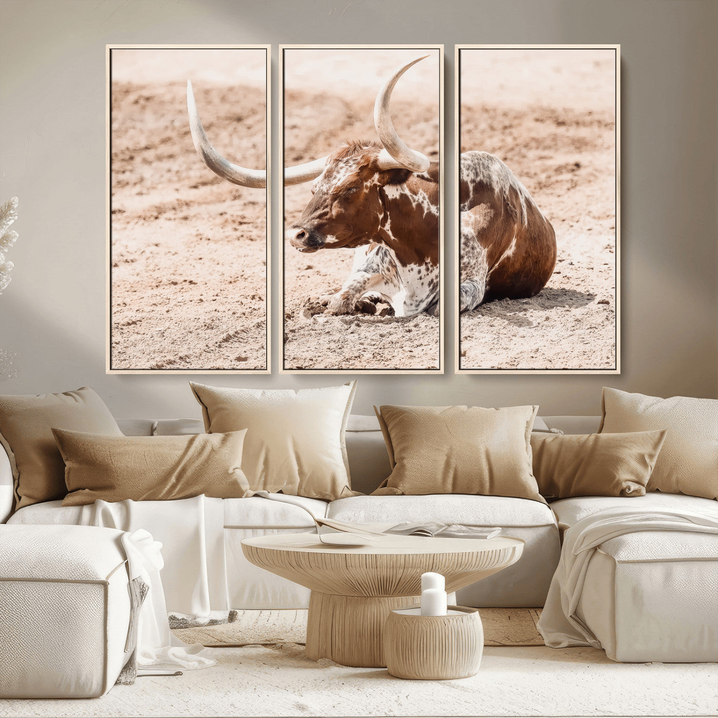 Texas Longhorn bull resting on dusty ground with warm tones, ideal for rustic western or farmhouse-themed wall decor.