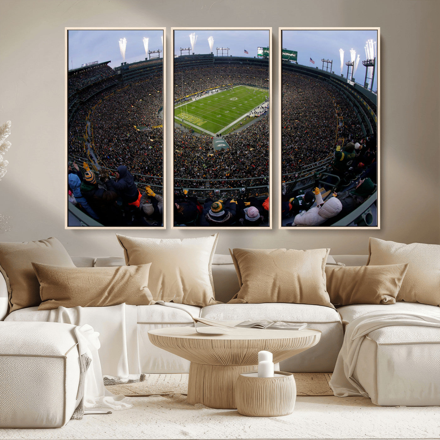Wide fisheye view of a packed Lambeau Field stadium during an American football game. The crowd fills the stands, and fireworks are going off above the stadium lights. The scoreboard displays "Touchdown," and the field has "Packers" painted in the end zon
