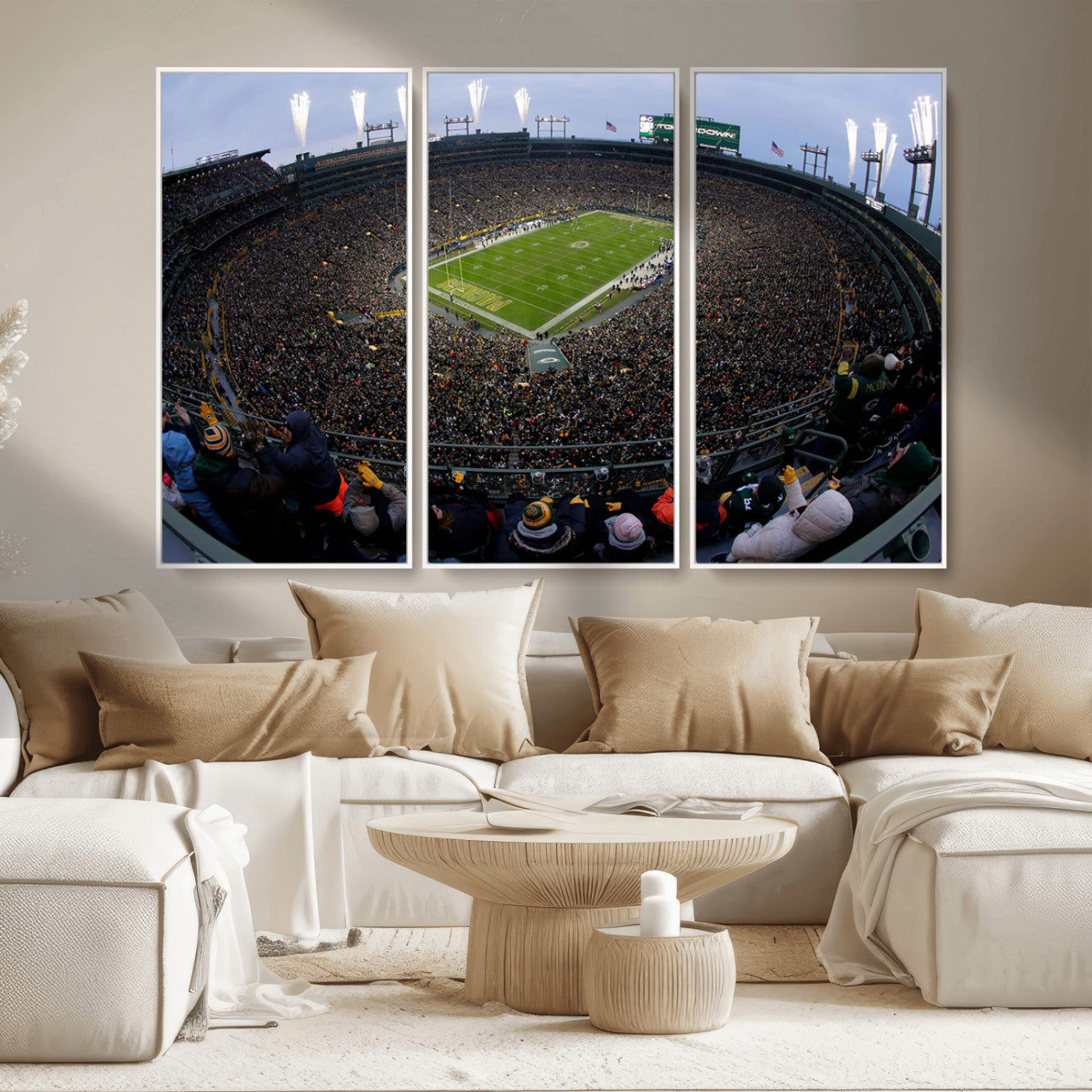 Wide fisheye view of a packed Lambeau Field stadium during an American football game. The crowd fills the stands, and fireworks are going off above the stadium lights. The scoreboard displays "Touchdown," and the field has "Packers" painted in the end zon