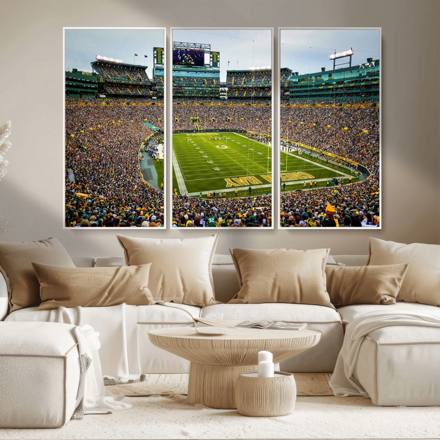 Packed football stadium with thousands of fans watching an American football game on a well-maintained field. The scoreboard displays "Lambeau Field," and players are lined up on the field. The stadium is surrounded by multiple tiers of seating filled wit