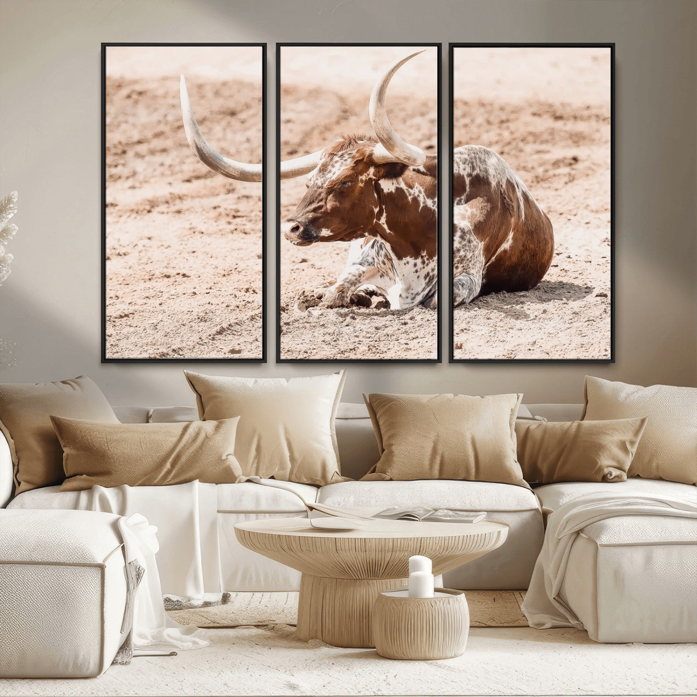 Texas Longhorn bull resting on dusty ground with warm tones, ideal for rustic western or farmhouse-themed wall decor.