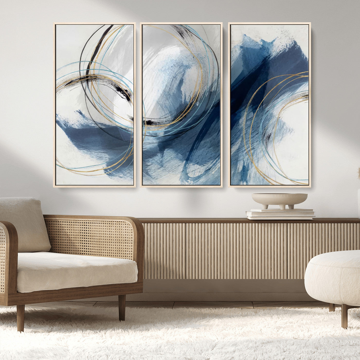 Abstract wall art featuring dynamic brush strokes in shades of blue and gray, overlaid with delicate circular line patterns in gold, black, and light blue on a white background.