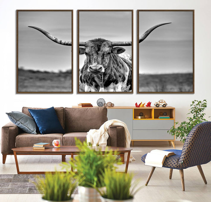 The Texas Longhorn Cow wall art, divided into three panels, is of gallery quality and displayed on a dark wall.