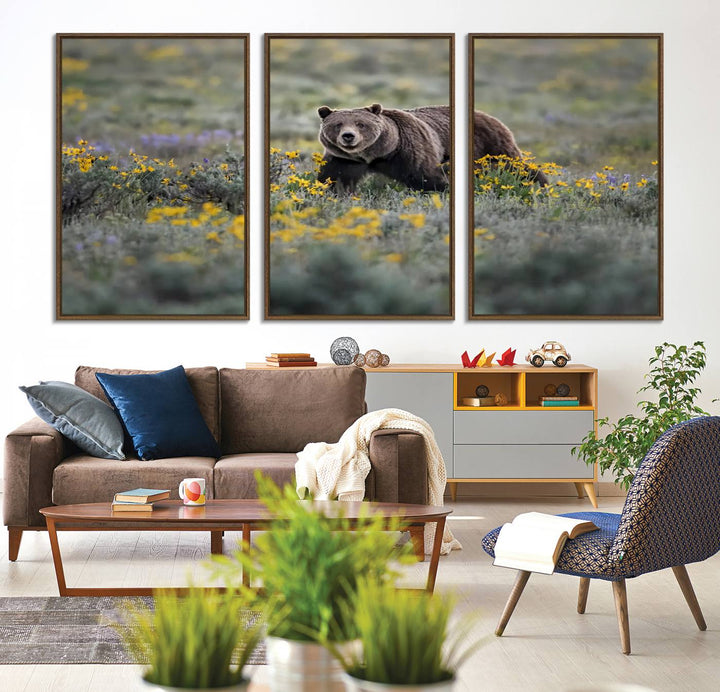 The "Grizzly 399 in Wild Flowers Wall Art Canvas Print" features a grizzly bear strolling through a field of yellow and purple flowers, beautifully showcased as a triptych. This handcrafted piece, proudly made in the USA, adds charm and sophistication to your space.