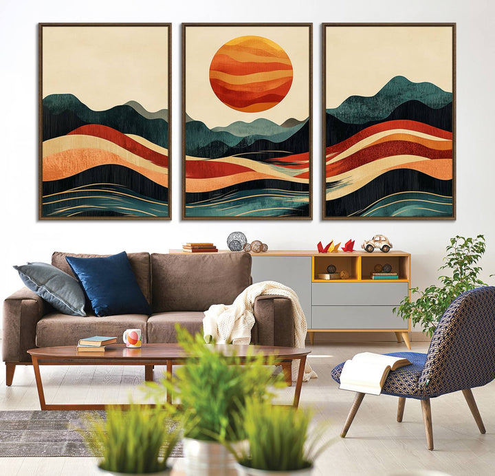 The Mountain Triptych wall art, featuring a design of the sun, mountains, and waves, is displayed prominently on the wall.