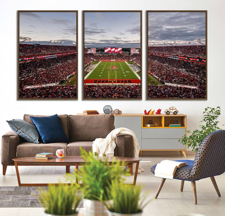 The wall art captures a stunning scene of Raymond James Stadium bathed in the warm hues of sunset. The sky, filled with clouds, provides a dramatic contrast to the vibrant lighting on the field, encapsulating the dynamic energy of a football game.