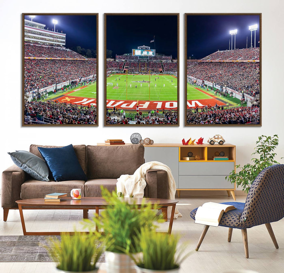 A NC State Wolfpack Football Team print of Carter-Finley Stadium at night features WOLFPACK illuminated brightly in the end zone grass.