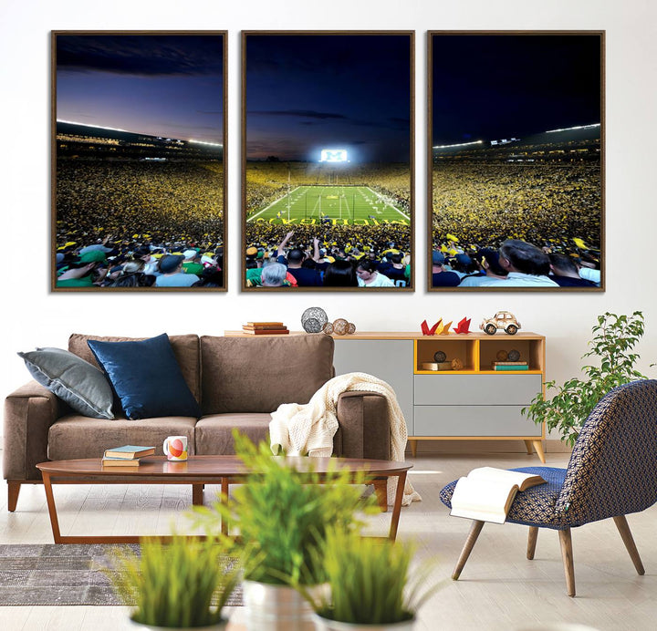 The wall art features a glowing M in this Michigan Wolverines Football Team Ann Arbor Stadium Canvas Print.